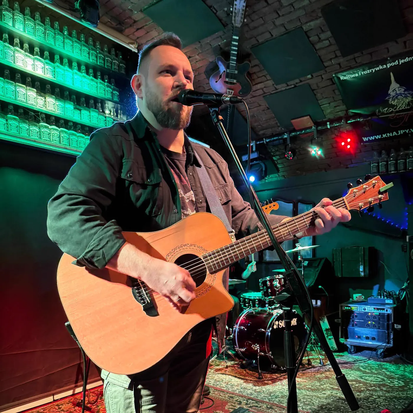 Grzegorz Komar Sikorski śpiewający i grający na gitarze